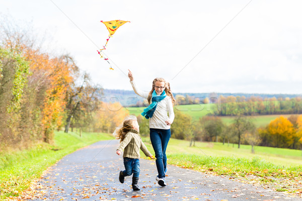 Girls fly an kite on autumn or fall meadow Stock photo © Kzenon
