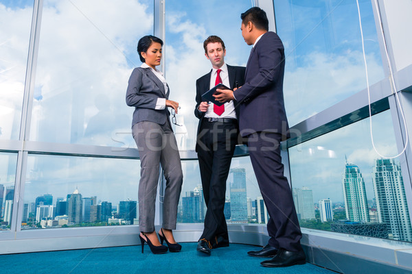 Businesspeople standing at office windo working Stock photo © Kzenon