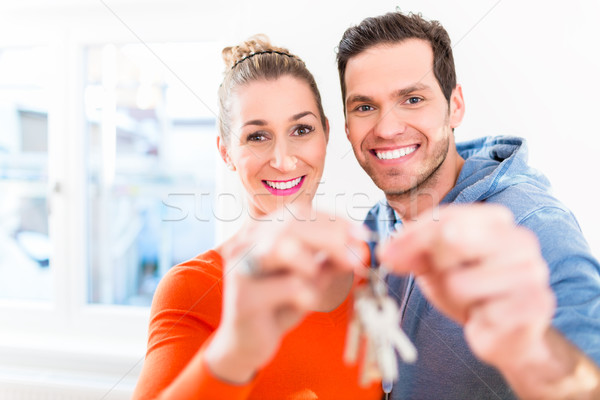 Woman and man holding proudly home or house key Stock photo © Kzenon
