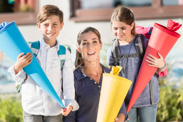 Mother and children on first day of school with candy cones Stock photo © Kzenon