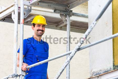 Skilled Asian worker controlling industrial hook Stock photo © Kzenon