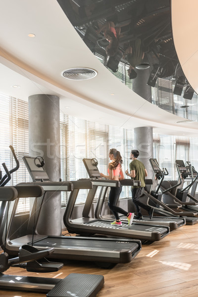 Young man and woman smiling while running side by side on electr Stock photo © Kzenon