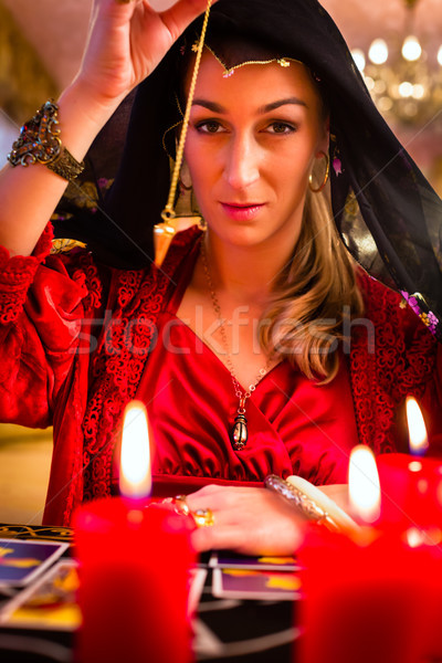 Radiesthesist in Seance dowsing with pendulum Stock photo © Kzenon