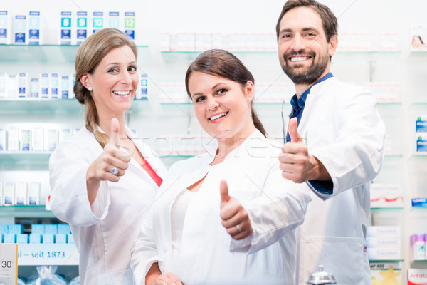 Pharmacists in pharmacy showing thumbs up Stock photo © Kzenon