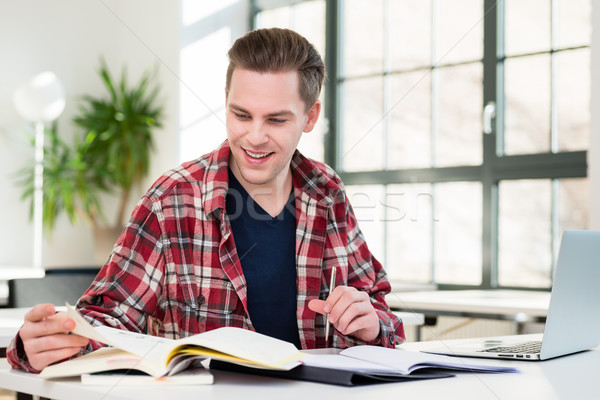 Portrait of a young student smiling while researching information Stock photo © Kzenon
