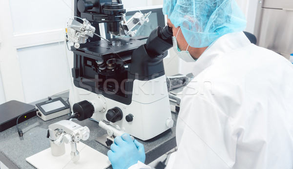 Stock photo: Doctor or scientist looking thru microscope in lab