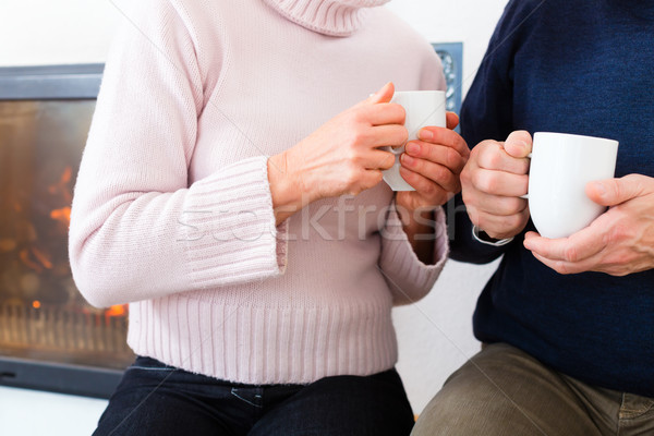 Seniors at home in front of fireplace with tea cup Stock photo © Kzenon