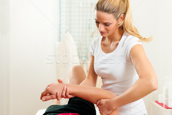 Patiënt fysiotherapie man oefening vrouwelijke arm Stockfoto © Kzenon