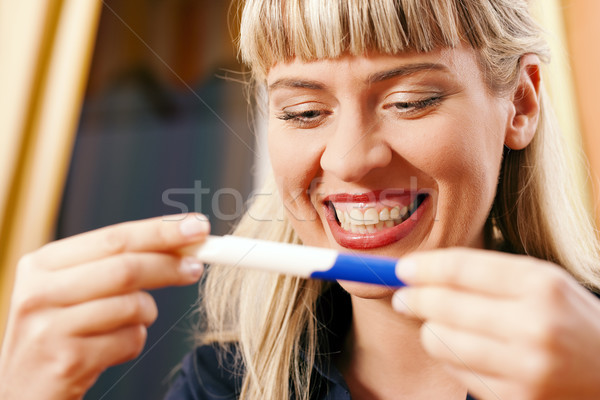 Mulher teste de gravidez feliz olhando animado grávida Foto stock © Kzenon