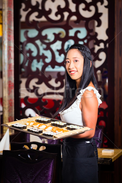 Stock photo: Waitress with sushi in asian restaurant