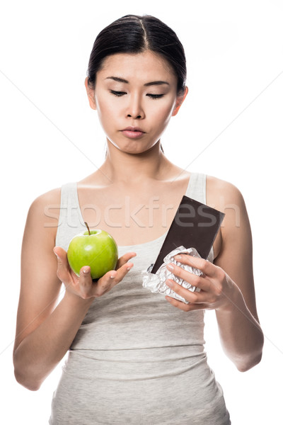 Pretty Asian woman debating an apple or chocolate Stock photo © Kzenon
