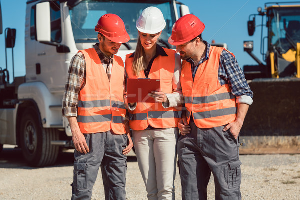 Truck drivers and dispatcher in front of lorries in freight forwarding company Stock photo © Kzenon