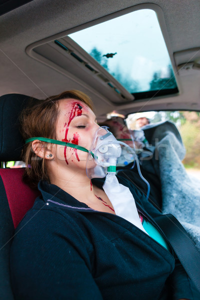 Car accident - Victim in crashed vehicle receiving first aid Stock photo © Kzenon