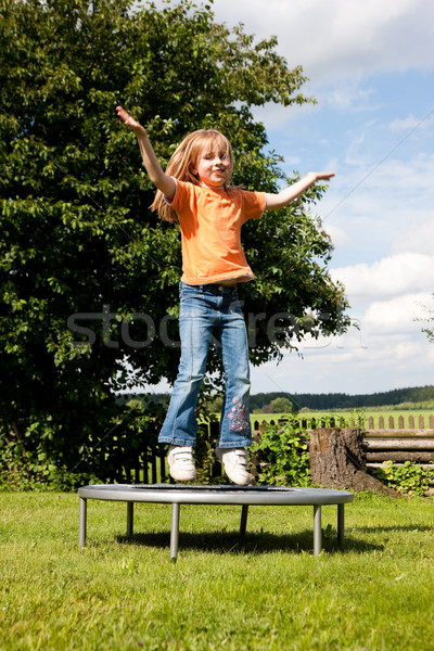 Girl child on trampoline in the garden Stock photo © Kzenon