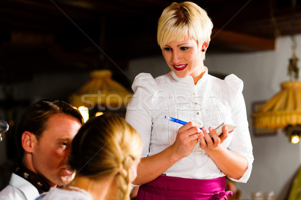 Waitress in Bavarian restaurant taking orders Stock photo © Kzenon