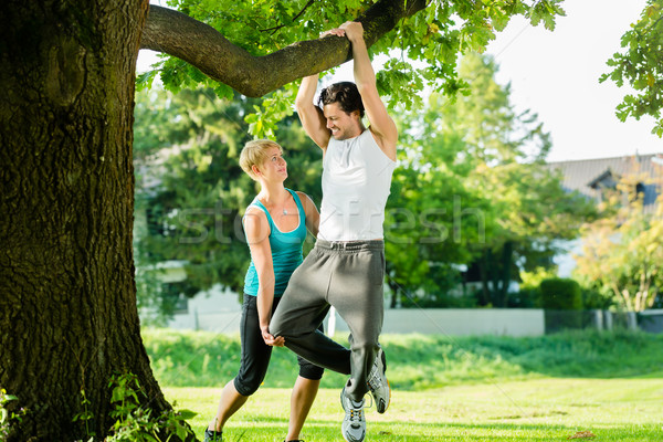 People in city park doing chins or pull ups on tree Stock photo © Kzenon