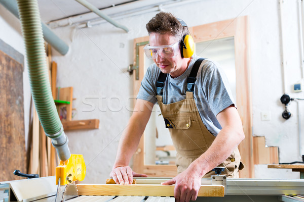 Carpenter using electric saw in carpentry Stock photo © Kzenon