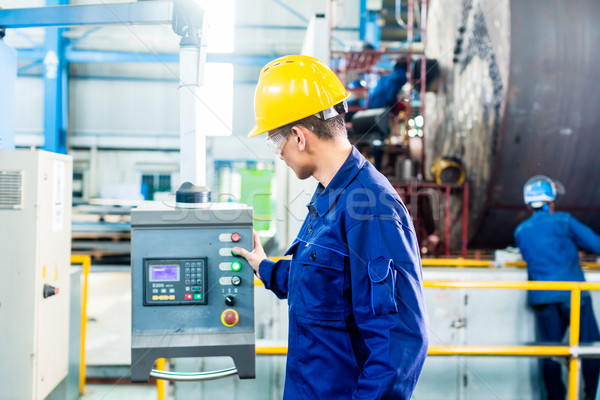 Stock photo: Worker in factory at machine control panel
