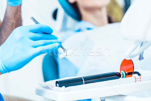 Close-up of the hand of a dentist preparing a dental LED curing  Stock photo © Kzenon