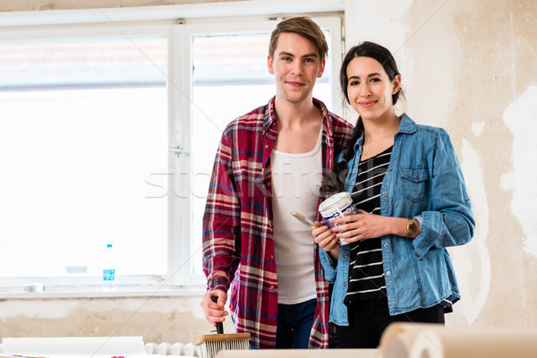 Stock photo: Portrait of a happy young couple holding tools for home remodeling