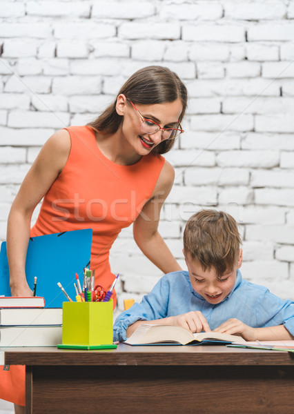 Mother helping her son to do the school homework Stock photo © Kzenon