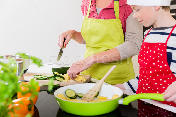 Mother cooking in the kitchen, son watching Stock photo © Kzenon