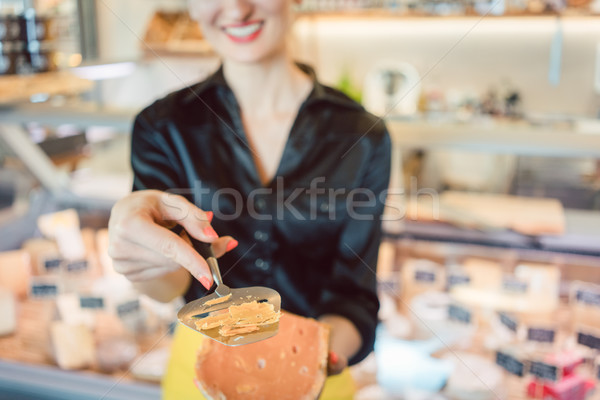 Beautiful woman offering cheese on delicatessen counter Stock photo © Kzenon