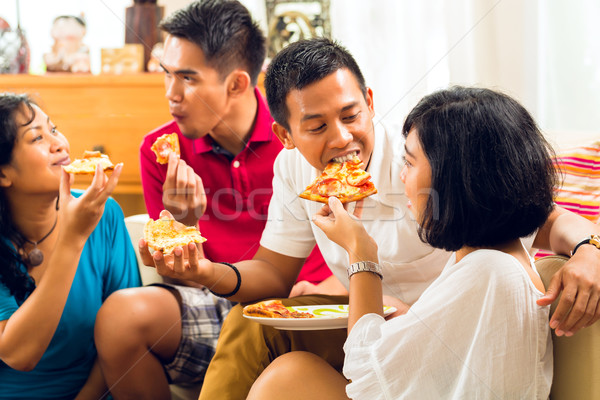 Asian people eating pizza at party Stock photo © Kzenon