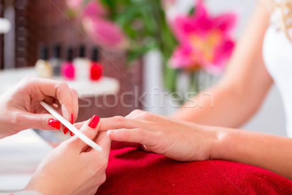 Woman at manicure in nail parlor with file Stock photo © Kzenon