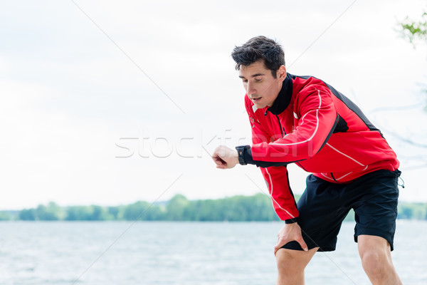 Woman and man at break from running in front of lake Stock photo © Kzenon