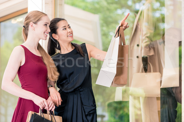 Two female best friends looking at the latest fashion trends whi Stock photo © Kzenon