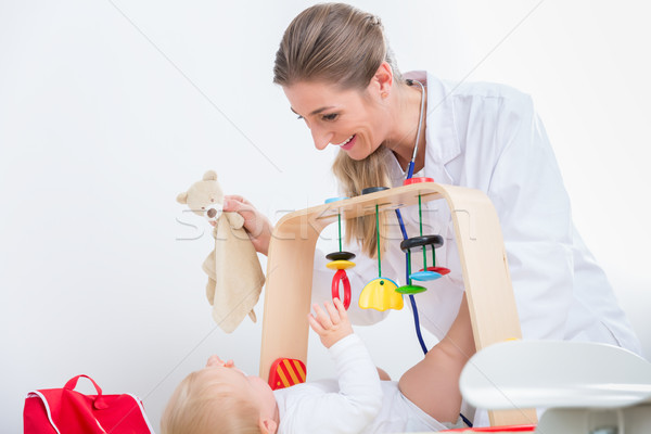 Dedicated pediatrician playing with a healthy and active baby Stock photo © Kzenon