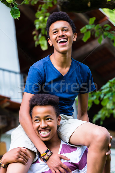 Boy carrying his friend on shoulder Stock photo © Kzenon