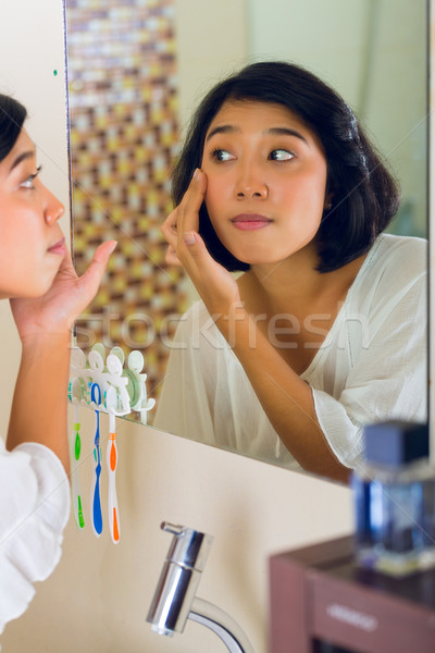 Asian woman discovering a pimple in face Stock photo © Kzenon