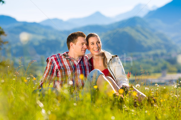 Couple is sitting in the meadow with mountain Stock photo © Kzenon