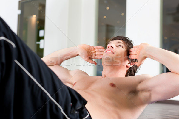 Man doing sit ups in gym Stock photo © Kzenon