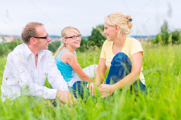Family sitting on grass of lawn or field Stock photo © Kzenon
