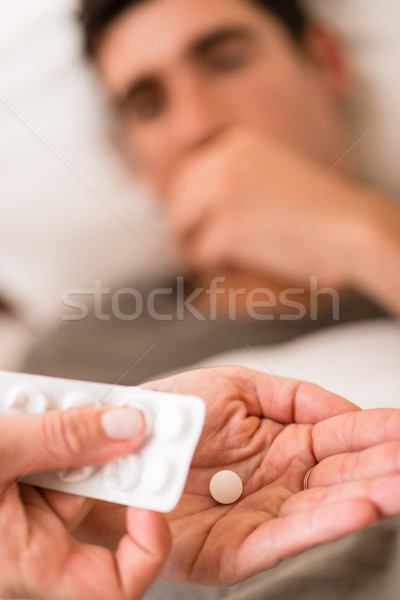 Wife or nurse giving a sick man medication Stock photo © Kzenon