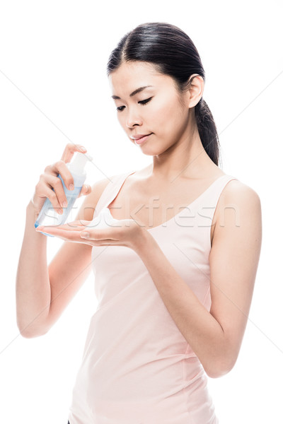 Young Asian woman pouring on hand cosmetic foam Stock photo © Kzenon