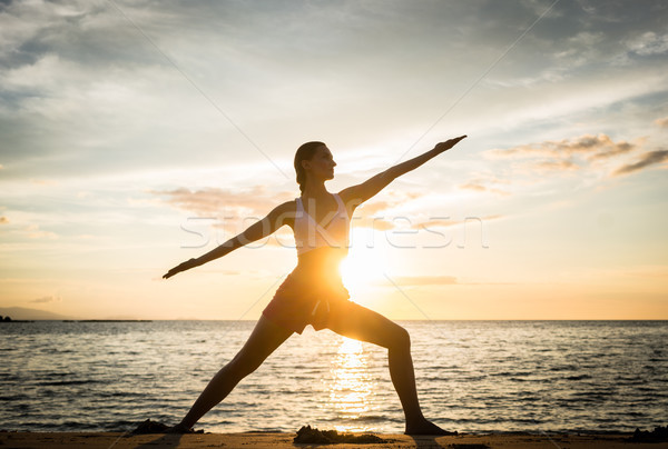 Sziluett fitt nő gyakorol harcos jóga póz Stock fotó © Kzenon