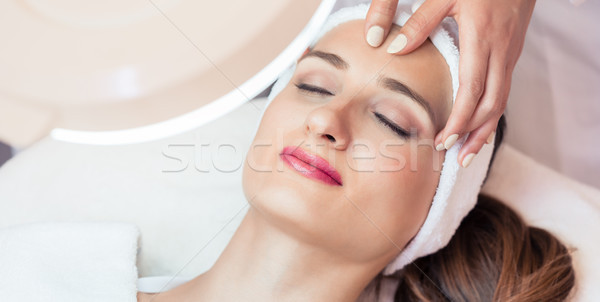 Relaxed woman smiling under the benefits of anti-aging facial ma Stock photo © Kzenon