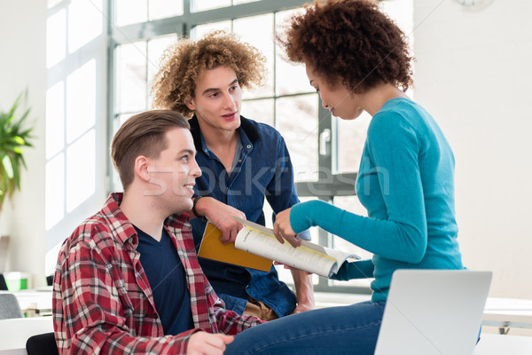 Three involved students sharing ideas and opinions about differe Stock photo © Kzenon
