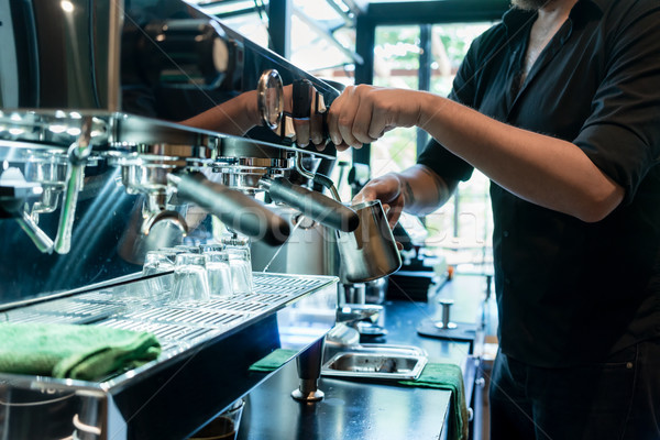 Hand of a barista holding a stainless mug while using a modern c Stock photo © Kzenon