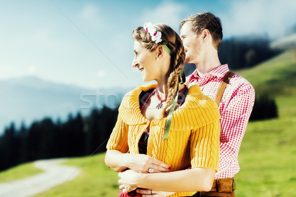 Couple in Tracht on Alp mountain summit at vacation Stock photo © Kzenon