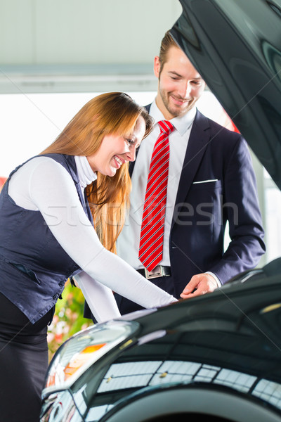 Young woman and seller with auto in car dealership Stock photo © Kzenon