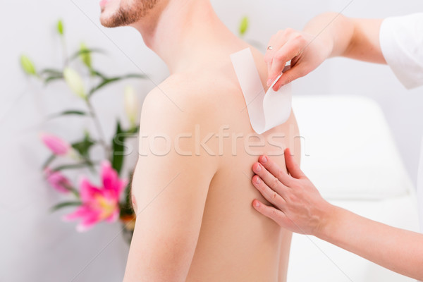 man at waxing hair removal in beauty parlor Stock photo © Kzenon