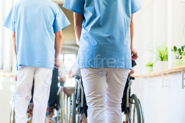 Krankenschwestern schieben Senioren Rollstuhl Pflegeheim Mann Stock foto © Kzenon