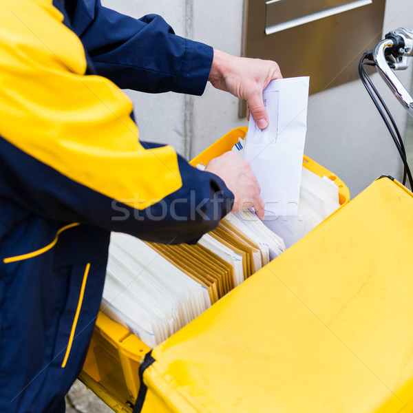 Postman delivering letters to mailbox of recipient Stock photo © Kzenon