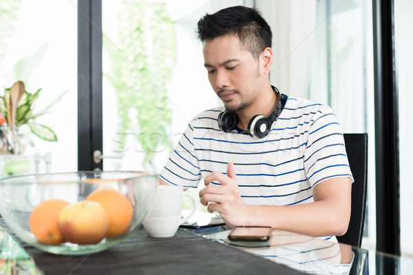 Indonésien homme potable café déjeuner écouter de la musique [[stock_photo]] © Kzenon