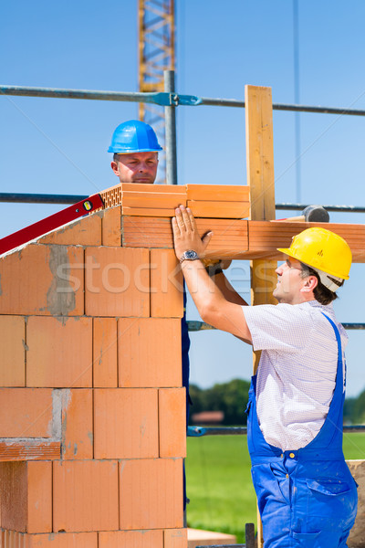 Bricklayer or builders on construction site working Stock photo © Kzenon